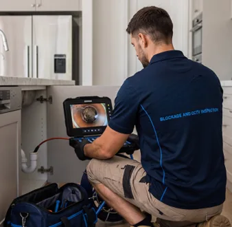Plumber clearing a blocked toilet in a Westleigh bathroom